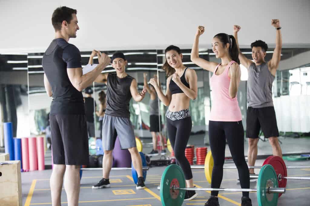 Young Chinese adult at gym with coach